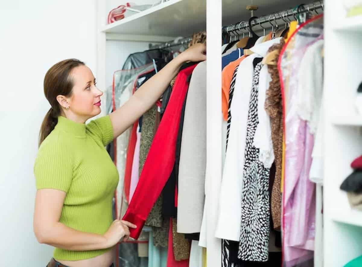 Mulher organizando roupas em armário