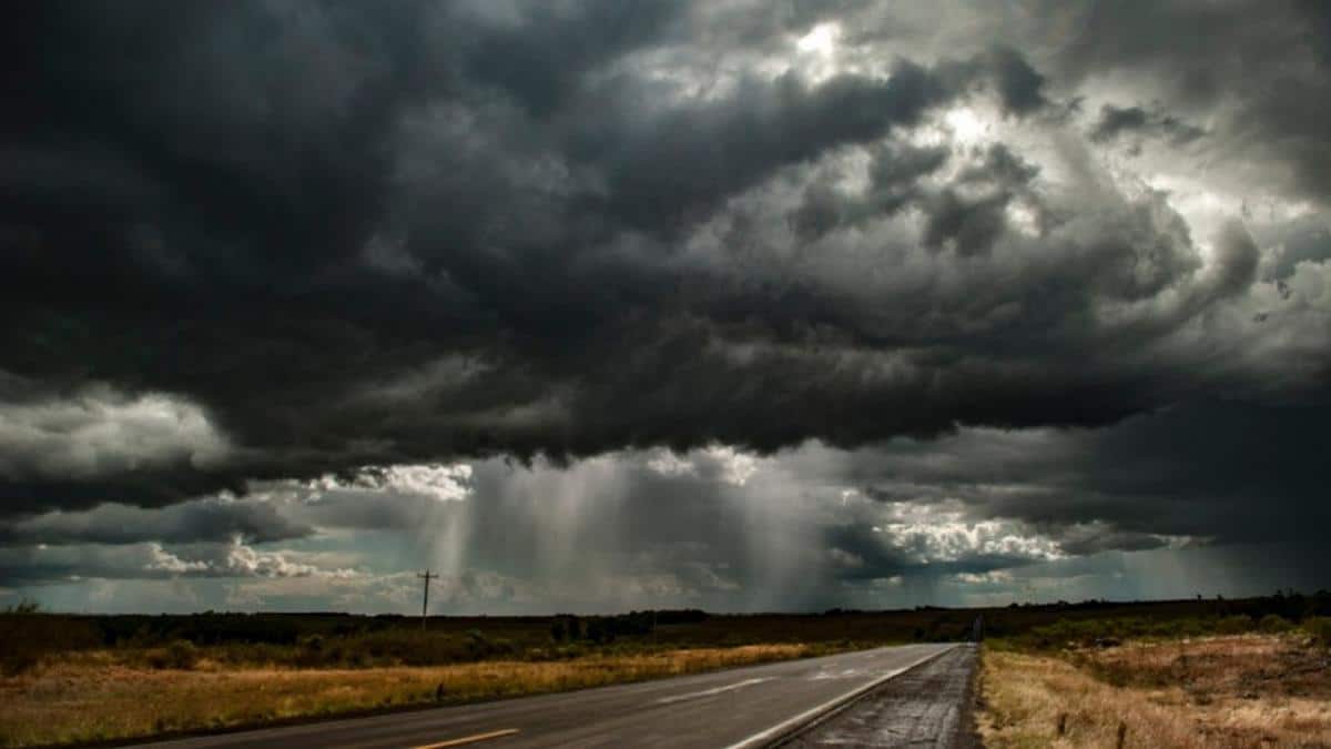 Foto mostra formação de chuva no Rio Grande do Sul, com nuvens carregadas em um campo aberto.