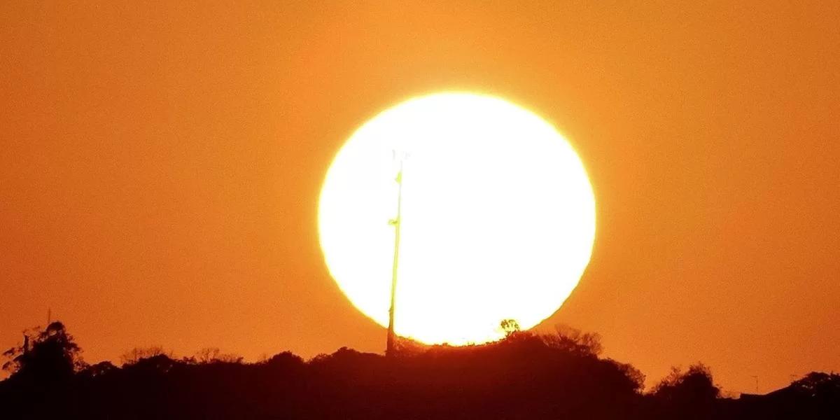 Foto mostra o sol em um céu alaranjado no RS. Imagem ilustrativa da onda de calor que atinge o Rio Grande do Sul.
