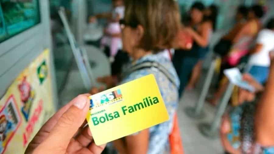 Foto mostra pessoa segurando o cartão do Bolsa Família.